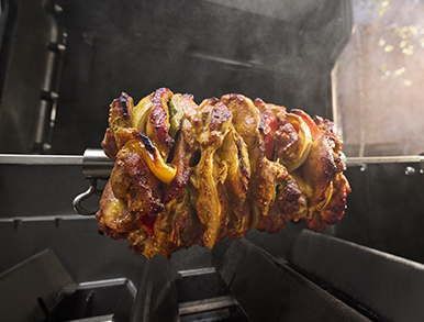 Meat and vegetable skewers turning on a rotisserie