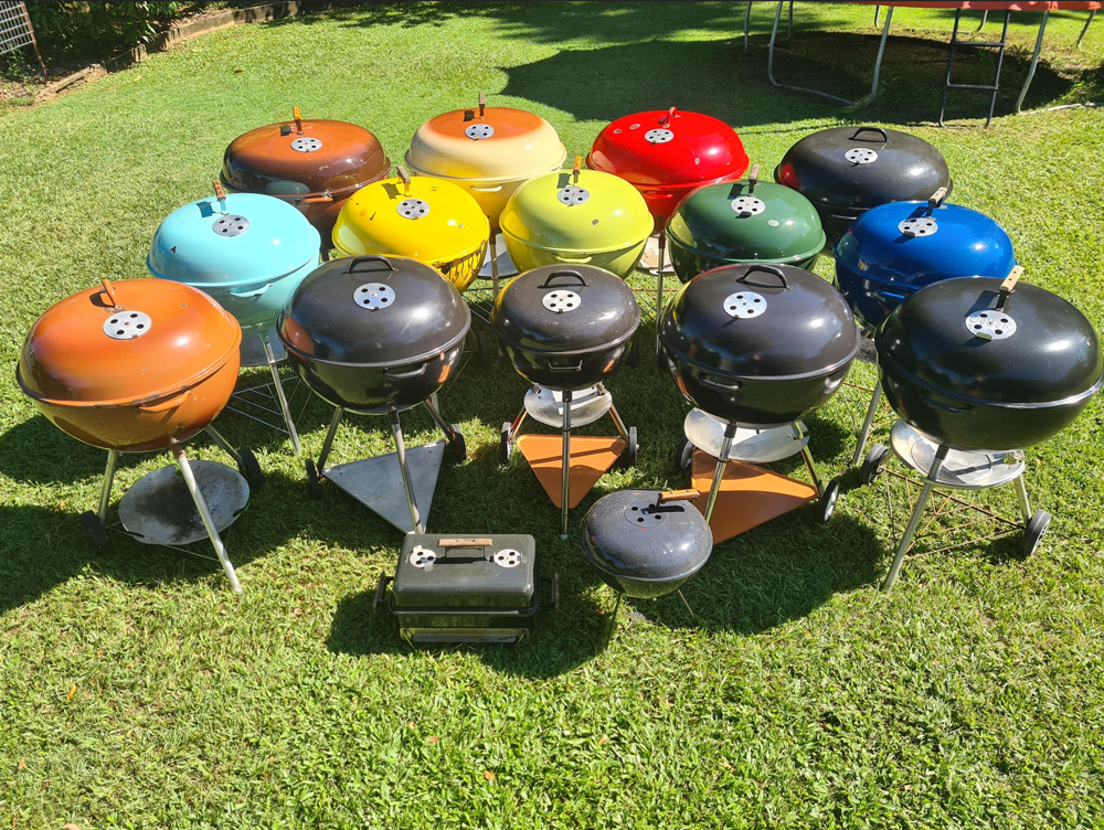 Large collection of colourful Weber kettles arranged on the lawn