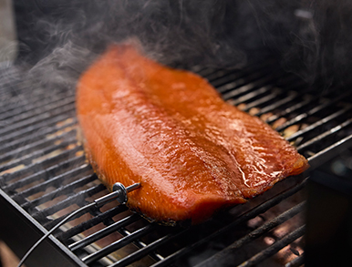 Salmon fillet smoking on the grill