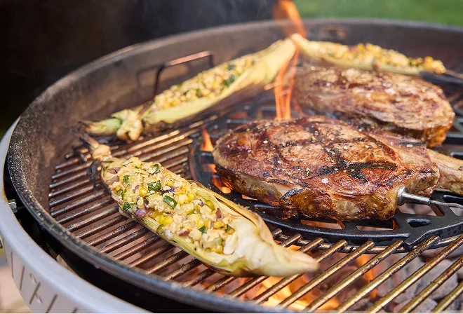 Weber Performer charcoal barbecue with food grilling evenly across the grate, showing consistent heat circulation