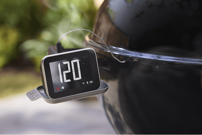 Weber smart hub display koblet til en Weber-kulegrill for overv&aring;king av mattemperaturen inne i grillen
