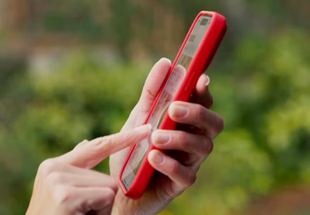 A person adjusts temperature settings on a smartphone displaying 250&deg;F in a cozy indoor environment.