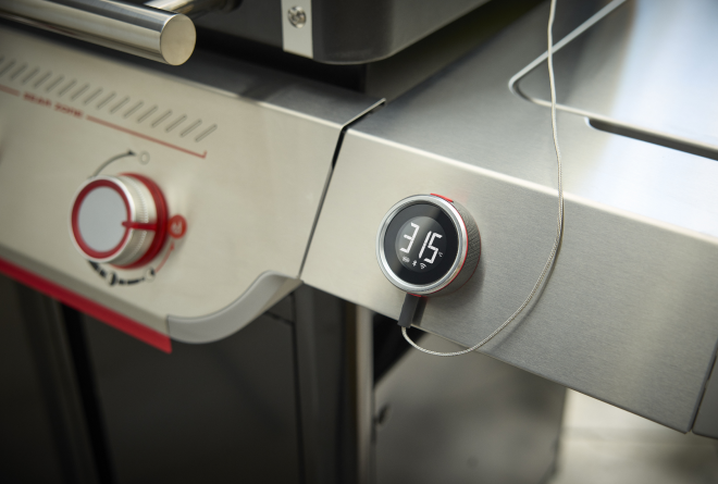 Ein Mann stellt die Temperatur an einem Weber Summit Smart Gasgrill ein