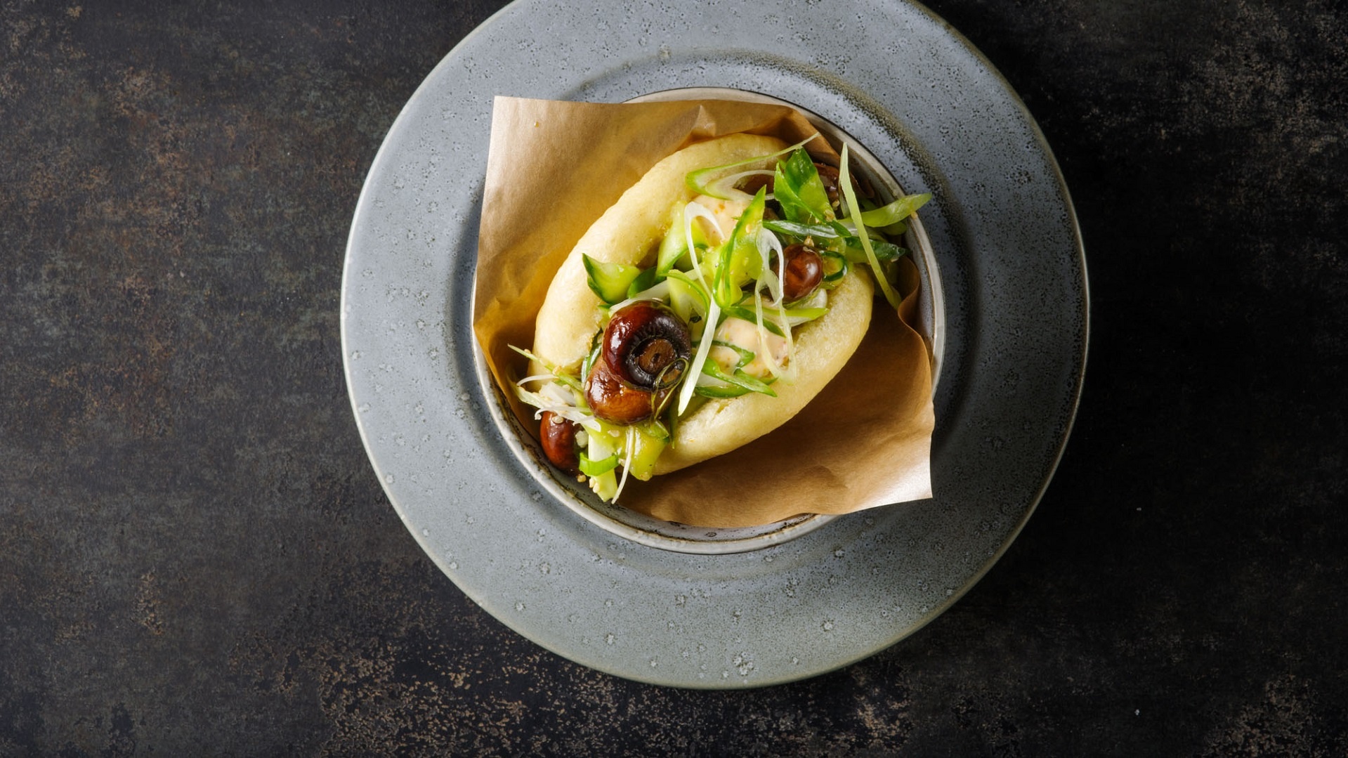 Asiatischer Streetfoodburger „Gua Bao Burger“ gefüllt mit Teriyaki Pilzen, Gurke und garniert mit Chili-Mayonnaise