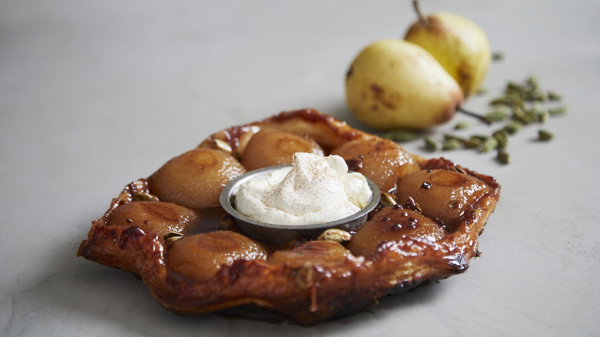  Sticky pear and cardamom tart Tatin with thick crème fraiche
