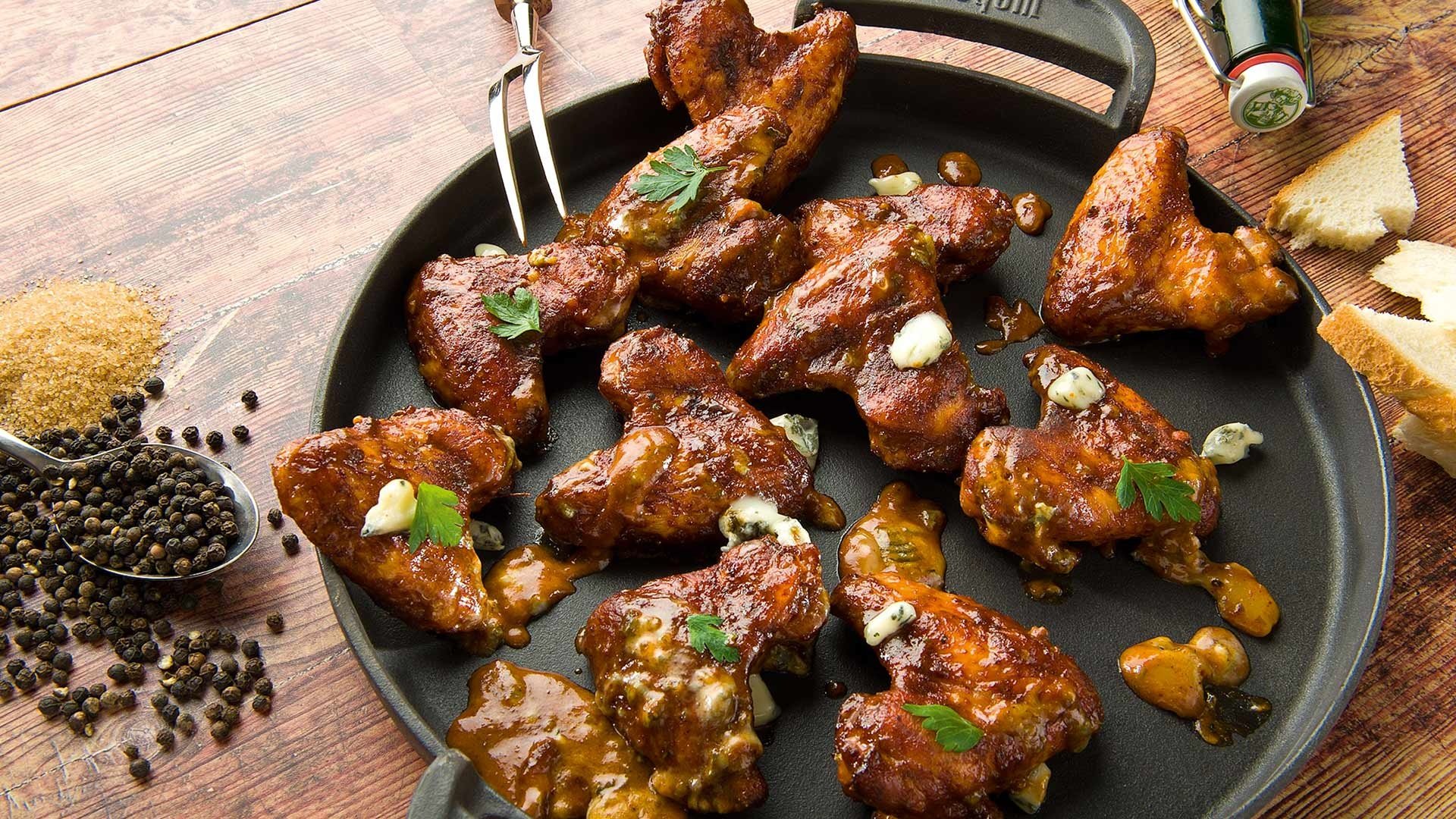  Spicy Chicken Wings mit unserer Bier-Infusion, in Apfelholz geräuchert mit Grillsauce und Gorgonzola


