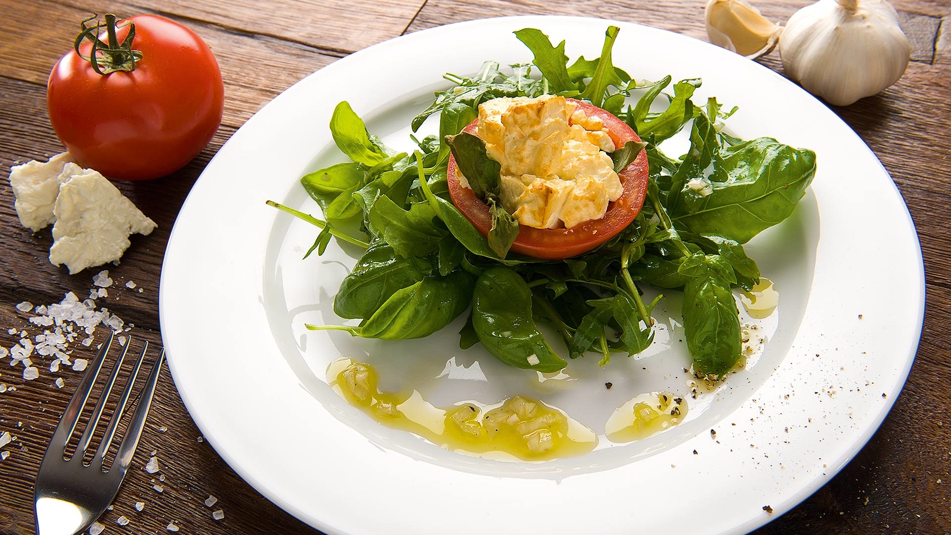 Schafskäse in der Tomate mit Kirschholzrauch auf Rucola