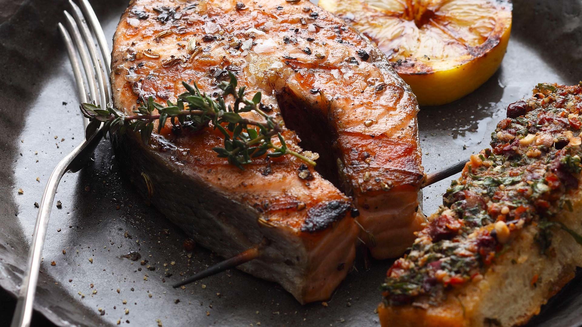  Lachskotelett an der Gr&auml;te gegrillt, dazu karamellisierte Zitrone und Ciabatta alla Puttanesca


